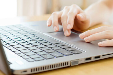 Hands typing on laptop computer