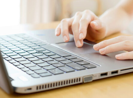 Hands typing on laptop computer