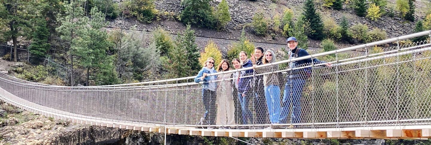 international students posing on cable bridge spanning kootenai falls