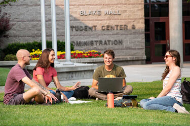 students sitting on the lawn
