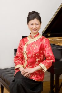 Ishang Lee portrait posing next to piano