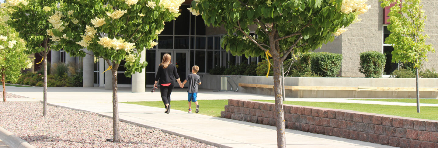 a woman and a child walk together on campus