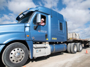 a man sits in an eighteen wheeler truck