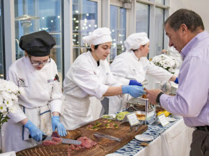 culinary students serving a guest