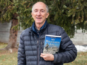 portait of author john fraley holding a copy of his book entitled my wilderness life