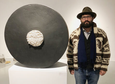artist Jospeh Pesina standing next to one of his ceramic artworks