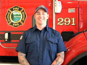 fire chief cole hadley posing for a portrait in front of ems vehicle