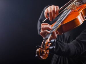 close up of musician's hands playing a violin