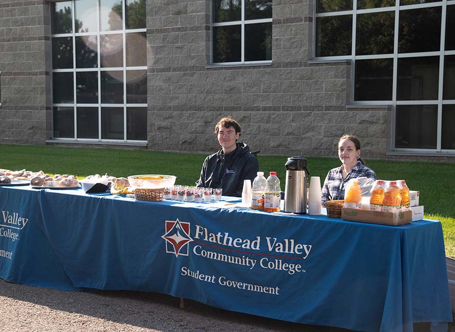 student government students serve lunch at a table outside blake hall