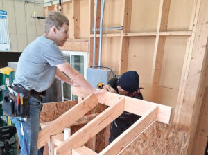 student working on framing as part of the building trades course