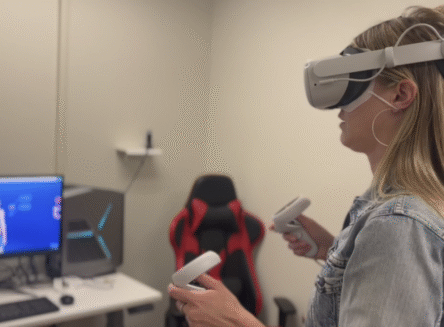 person in virtual reality headset and controls in FVCC's Makerspace