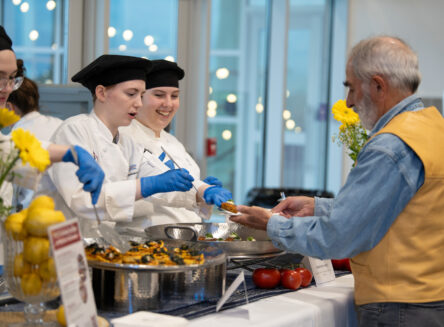 culinary students serving a Grand Wine Tasting attendee