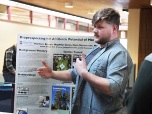 student presenting research poster