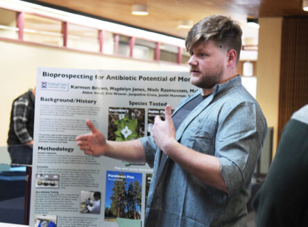 student presenting research poster