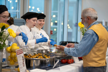 culinary students serve attendee at the grand wine tasting