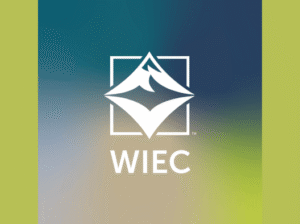 The logo for the Wachholz Innovation and Entrepreneurship Center featuring a white mountain peak icon inside a square frame above the letters WIEC, centered on a blue and green gradient background.