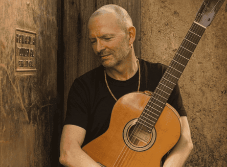 Guitarist Ottmar Liebert performing his Nouveau Flamenco style on an acoustic guitar at the McClaren Hall stage in the Wachholz College Center.